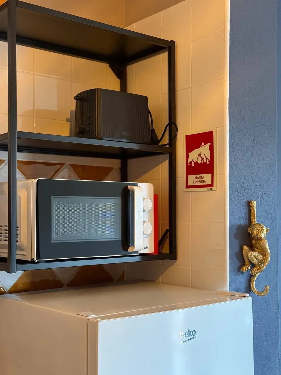 Kitchen shelf with microwave, toaster, and fridge below